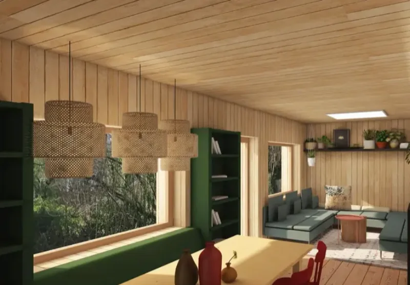 Séjour d’une maison familiale avec bardage bois intérieur, banquette verte et grande baie sur le jardin